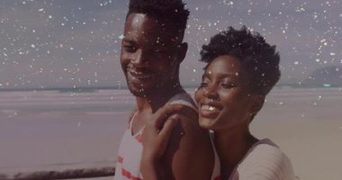 Okyanus kenarındaki trabzanlar üzerinde pazarlama reklamı için poz veren çift, etrafta dijital konfeti sallıyor. Romantizm, kutlama, neşe, açık hava, eğlence, mutluluk, huzur