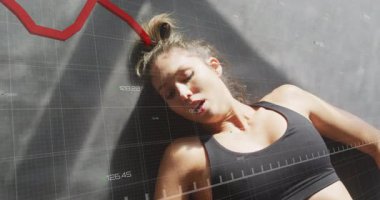 Spor salonunda uzanan bayan sporcu, eldivenli elini kaldırarak alçalan kırmızı veri akımına karşı savunma yapıyor. Performans, esneklik, kararlılık, uygunluk, veri görselleştirme, güç, konsantrasyon