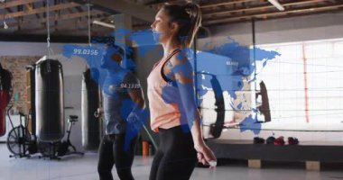 Antrenman partnerleri yukarıdan ip sallıyor ve harita kaplamalı fitness stüdyosunda kardiyo için zıplıyorlar. Atletik, işbirliği, dinamik, modern, sağlık, hareket, dayanıklılık