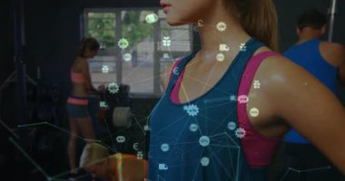 Kamera spor salonu üyesine yakınlaşıyor ve fitness teknolojisi için titreşen ağ ve para birimi simgelerini vurguluyor. Fitness, güçlendirme, teknoloji, güç, kararlılık, sağlık, canlılık