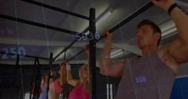 Fitness katılımcıları barfiks çubuklarını kavrayıp istatistikleri güncellerken aynı anda barfiks çekiyorlar. Güç, egzersiz, performans, spor, eğitim, canlılık, teknoloji