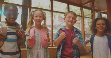 Sınıftaki çeşitli öğrencilerin gülümsemesi üzerine parlayan ışık görüntüsü. Eğitim, öğrenme ve geliştirme konsepti dijital olarak oluşturulmuş imaj.