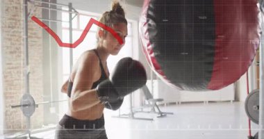 Fitness stajyeri yumruk atmaya ve kum torbasını kancaya takmaya başlıyor, güç trendlerini çizgi grafiğiyle izliyor. Jimnastik, atletizm, eğitim, güç, kararlılık, dinamik, hareket