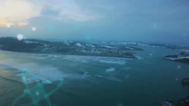 Üç karlı kıyı haritası üzerinde yukarı doğru sürüklenen, parlayan deniz mavisi dijital ağ çerçevesinde dalga hatları. Hava görüntüsü, manzara, teknoloji, bağlantı, doğa, yenilik, dijital