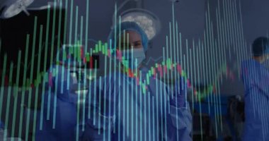 Cerrah elini kaldırıyor, hasta izleme için tıbbi ameliyathanede veri tablolarını inceliyor. Tıbbi, sağlık, teknoloji, yenilik, profesyonellik, klinik, tanı