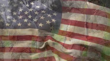 Kadın ve erkek asker çimlerin üzerinde diz çöküyor, askeri bayrak ikilisi kayboluyor. Vatanseverlik, birlik, disiplin, kamuflaj, hazırlık, esneklik, takım çalışması