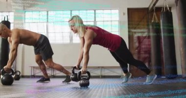 Jimnastik ikilisi elinde kettlebell kalası tutuyor, kadın sırayla çekirdekleri hedef alıyor erkek de dengeyi sağlıyor. Zindelik, güç, idman, antrenman, atletizm, direnç, koşullanma