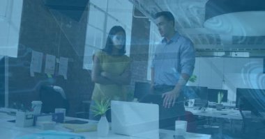 Dizüstü bilgisayara yaslanan ve onu işaret eden bir adam animasyon çizelgelerini başlatarak meslektaşına yol gösteriyor. İşbirliği, takım çalışması, yenilik, profesyonel, üretkenlik, iletişim, modern ofis