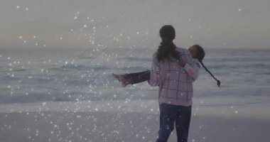 Sağlık odaklı anne gün batımında kıyıda yürüyor dalgaların arasında duruyor ve kızını kaldırıyor sonra da dönüyor. Aile, bağ, açık hava, dinginlik, şefkat, rahatlık, manzara