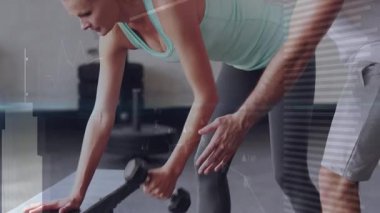 Müşteri spor salonundaki tezgahı elle, dizle destekliyor, dambılı çekerek antreman pozisyonuna rehberlik ediyor. Kuvvet eğitimi, kişisel koçluk, fitness süreci, atletik performans, egzersiz motivasyonu, spor salonu ortamı, fonksiyonel hareket