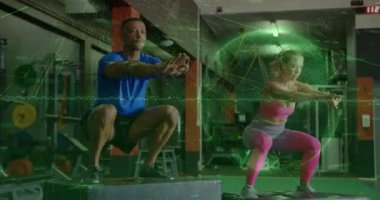 Antrenman partnerlerini durdurduktan sonra kutulara bastıktan sonra jimnastik salonunda yeşil kaplamayla atladıktan sonra. Eğitim, fitness, yoğunluk, güç, atletizm, senkronizasyon, performans