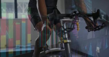 Dayanıklı sporcu montaj bisikleti, fitness laboratuarında pedal çevirmek maske takmak, grafikleri takip etmek. Performans, biyomekanik, fitness, teknoloji, spor, dayanıklılık, veri görselleştirme