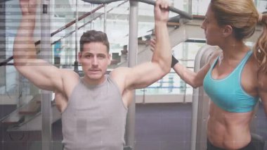 Spor salonu müşterisi antrenör rehberliğiyle sırt desteği için yukarı çekme çubuğunu aşağı çekmeden önce nefes alıyor. Kuvvet, egzersiz, fitness, eğitim, kas gücü, dayanıklılık, aktif giyim