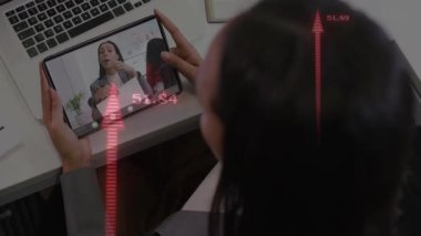 Kadın tablet kaldırma takımı çağrı yaparken akran rapor sunuyor ve kırmızı oklar ölçümleri gösteriyor. İşbirliği, iletişim, teknoloji, profesyonel, analitik, dijital, üretkenlik