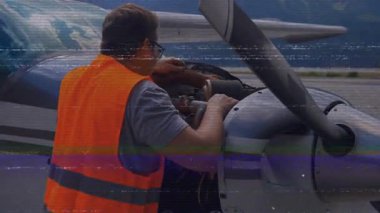 Havacılık teknisyeni, dağ önlüğünün kapağını açtıktan sonra hortumları kontrol ediyor. Tamirci, uzay, endüstriyel, bakım, engebeli, teknik, mühendislik