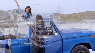 Kıyıda mavi kamyonetle bir çift beşlik çakıyor AR taraması başlatılıyor ve görüntüleme analizi tamamlandı. Macera, romantizm, sahil, keşif, teknoloji, açık hava, bağlantı