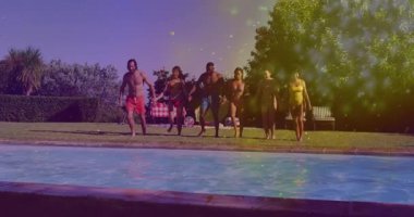 Çim sınırında el ele tutuşan bir grup arkadaş dizlerini bükerek havuz tatiline atlıyorlar. Açık hava eğlencesi, sosyal aktivite, boş zaman, yaz, mutluluk, neşe, neşe