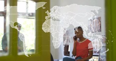 Kadın tasarım merkezindeki telefonu arıyor. Meslektaşı tablet klasörünü araklarken harita üzerinde titreşim oluşturuyor. İşbirliği, yenilik, çalışma alanı, iletişim, teknoloji, yaratıcılık, takım çalışması