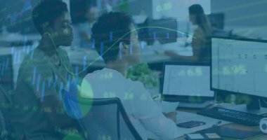 Oturan analistin üzerine eğilen ve veri incelemesini finans grafiği örtüleriyle yönlendiren bir meslektaşım. İşbirliği, takım çalışması, veri analizi, ofis, teknoloji, profesyonel, modern