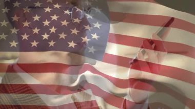 Hekim akıllı telefon kaldırıyor ve ekranı kaydırıp notlar yazarken bayrak kaplamasını etkinleştiriyor. Tıbbi, doktor, sağlık, profesyonel, iletişim, teknoloji, vatanseverlik