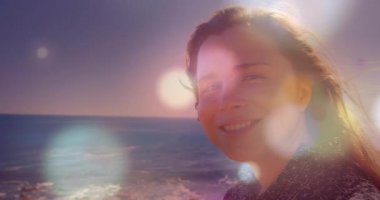 Güneş 'in alçalması lenslerin parlamasına neden oluyor, kadın gülümsüyor, başını kırpıyor rüya gibi bir seyahat havası yaratıyor. Deniz manzarası, sükunet, dinginlik, açık hava, ufuk, doğal, düşünceli.