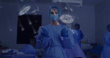 Baş cerrah el kaldırıyor ve ekip hazırlanırken ameliyathanede ikili kaplamayı etkinleştiriyor. Tıbbi, sağlık, teknoloji, yenilik, kesinlik, takım çalışması, kısır