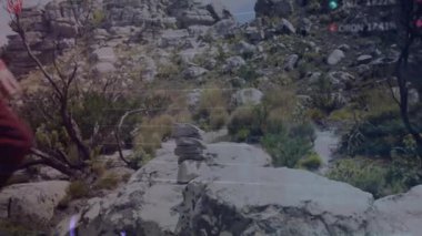 Yürüyüşçü kaya platformuna adım atıyor, çölde seyrüsefer için Cairn 'e düz taş yerleştiriyor. Macera, keşif, engebeli arazi, dayanıklılık, başarı, açık hava