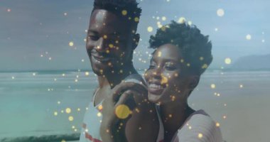 Couple posing beach initiating golden particles drifting, accentuating expressions for marketing. Romance, serenity, celebration, elegance, natural, glow, affectionate