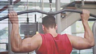 Kırmızı tişörtlü bir adam, etek çekme hareketini ayarlıyor ve tekrar tekrar zindelik için çubuğu aşağı çekiyor. Güç, egzersiz, fitness, spor salonu, direnç, antrenman, kas gücü