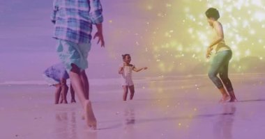 Dede ailesinin peşinden koşan altın parıltılarıyla sağlık için denize sıçrayan bir çocuk. Aile, sahil, su oyunu, boş zaman, açık hava, mutluluk, güneş ışığı.