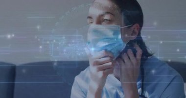 Tıbbi maske takan kadın maske takarken ve sağlık verileri ile telefon görüşmesi yaparken. Kişisel koruma ekipmanları, telekomünikasyon, dijital arayüz, modern yaşam tarzı, sağlık teknolojisi, iç mekan ayarları, sağlık