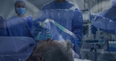 Anestezi uzmanı ameliyata hazırlanan hastaya maske takıyor ve tüpü makineye bağlıyor. Tıbbi, ameliyathane, sağlık, steril, takım çalışması, klinik, hassasiyet