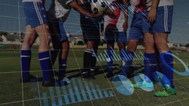 Maç öncesi bir araya gelen futbol takım arkadaşları ellerini topun üzerine koyup dijital veri aktarımı yapıyorlar. Takım çalışması, arkadaşlık, rekabet, atletizm, birlik, spor, kararlılık