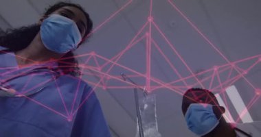 Sağlık ekibi hasta IV. Direk 'in yanına yaslanmış, değişen pembe ağ kaplamalı hayati göstergeleri izliyor. Tıp uzmanları, klinik çevre, geleceksel arayüz, dijital sağlık, hasta izleme, takım çalışması, sağlık teknolojisi