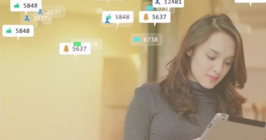 İçerik yaratıcı ofiste tablet okuyor, ekranı tıklatıyor ve yüzen sosyal medya ölçümlerini takip ediyor. Dijital, teknoloji, modern, profesyonel, minimalist, sosyal medya, katılım