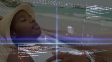 Hamaktaki kadın elini kaldırıyor ve gökyüzüne bakıyor. Plaj teknolojisi üzerinde ikili kodu etkinleştiriyor. Dijital, fütüristik, sakin, tropikal, ağ, bağlantı, rahatlama