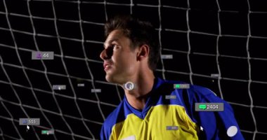 Kaleci sıçrama yapıp gelen futbol topunu yakalarken nişan simgelerini tarıyor ve başlatıyor. Sporcu, aksiyon, dijital, gece, spor, eğitim, rekabetçi