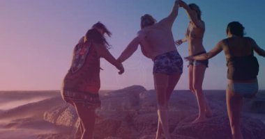 Dostlar gün batımında el ele tutuşur kayalık kıyılardan iner dalgalar birbirini destekler. Macera, yoldaşlık, keşif, arkadaşlık, esneklik, kıyı, dinamik