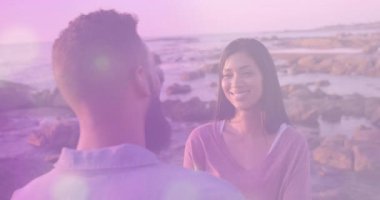 Erkek başını çevirir ve konuşur. Günbatımı mercekleriyle kadının romantik gülüşüne neden olur. Romantizm, samimiyet, doğa, sükunet, samimiyet, altın saat, manzara