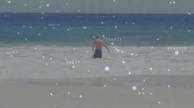 Son sınıf öğrencisi sörf yapıyor, daha derin denge içinde yürüyor teknoloji etiketlerle kaplanırken. Son sınıf, plaj, okyanus, dalgalar, sükunet, rahatlık, dijital kaplama