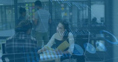 Kadın raporları açıyor ve mesai arkadaşları olarak saydam çizelgeleri gösteriyor. Ofis toplantısına yapışkan ekliyorlar. İşbirliği, takım çalışması, veri analizi, iş stratejisi, modern çalışma alanı, profesyonel tartışma, üretkenlik