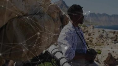 Adam kanyon çıkıntısında kamerayı yakalıyor ve teknik grafikler yüzerken göl manzarasını çekiyor. Macera, manzara, doğa, açık hava, keşif, fotoğrafçılık, engebeli