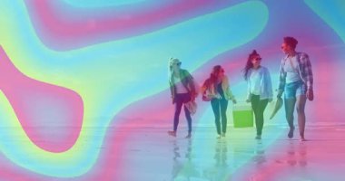 Güneş ışığı seyahat grubu ıslak kumda yürürken ayşapkası serinletici taşır. Kumsal, arkadaşlık, boş zaman, açık hava, coşku, rahatlama, yaşam tarzı.