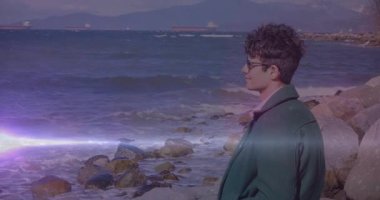 Seyahat görüntüleri yeşil ceketli bir adamın kayalık deniz merceğinden yürüyüşünü gösteriyor. Dramatik, tefekkür, macera, manzara, sinematik, yalnızlık, manzara