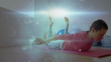 Fitness yoga pratisyenleri kollarını öne koyuyorlar kıvılcımlar saçarak parlayan örtülerle poz veriyorlar. Esneme, esneklik, sağIık, farkındalık, rahatlama, kemerli, uyum