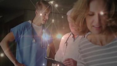 Kıdemli tıp doktoru tableti tıkırdatıyor. Ana-kız kılavuz ağıyla bağlantı kuruyor. Sağlık, hasta bakımı, takım çalışması, tıbbi danışma, dijital teknoloji, pediatrik, profesyonel