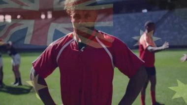 Rugby oyuncusu, Avustralya bayrağının solması üzerine sahaya dik dik bakıyor, odak noktasını vurguluyor. Sporcu, takım çalışması, stadyum, antrenman, disiplin, kararlılık, spor