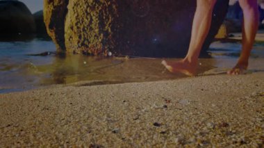 Erkek, sörf yapmak için sağ ayağını kaldırıyor. Teknoloji gösterisi için kumların etrafında dalgalanan dijital örtüler oluşturuyor. Minimalist, gelecekçi, kıyı şeridi, holografik, enerji, adaptasyon, hareketlilik