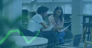 Basılı çizelgeleri tutan ve yeşil finans grafiğini çalıştıran meslektaşlar yükselip alçalıyorlar. İşbirliği, analitik, takım çalışması, veri görselleştirme, ofis, profesyonel, modern