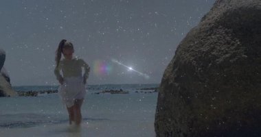 Çocuk ıslanmamak, seyahat sahnesinde kayaya yaklaşmamak için sahil suyu kaldırma eteğine basıyor. Macera, keşif, deniz kenarı, tasasız, genç, doğa, canlılık